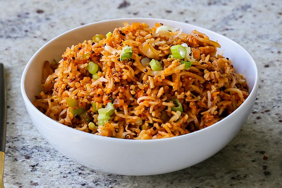 Schezwan fried rice in a bowl with green onions for garnish