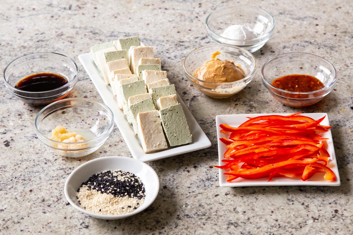 ingredients needed for making sesame crusted tofu bowls on a concrete countertop