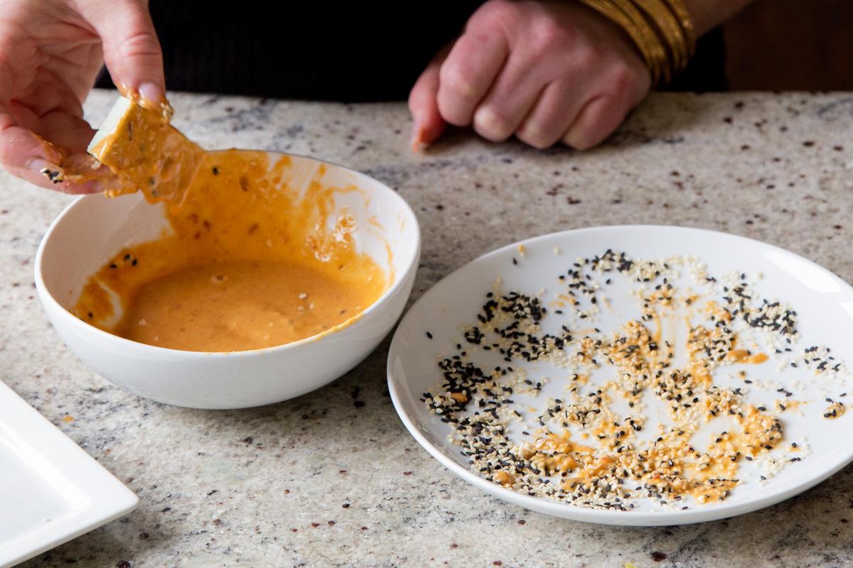 a piece of tofu being tossed in peanut sauce