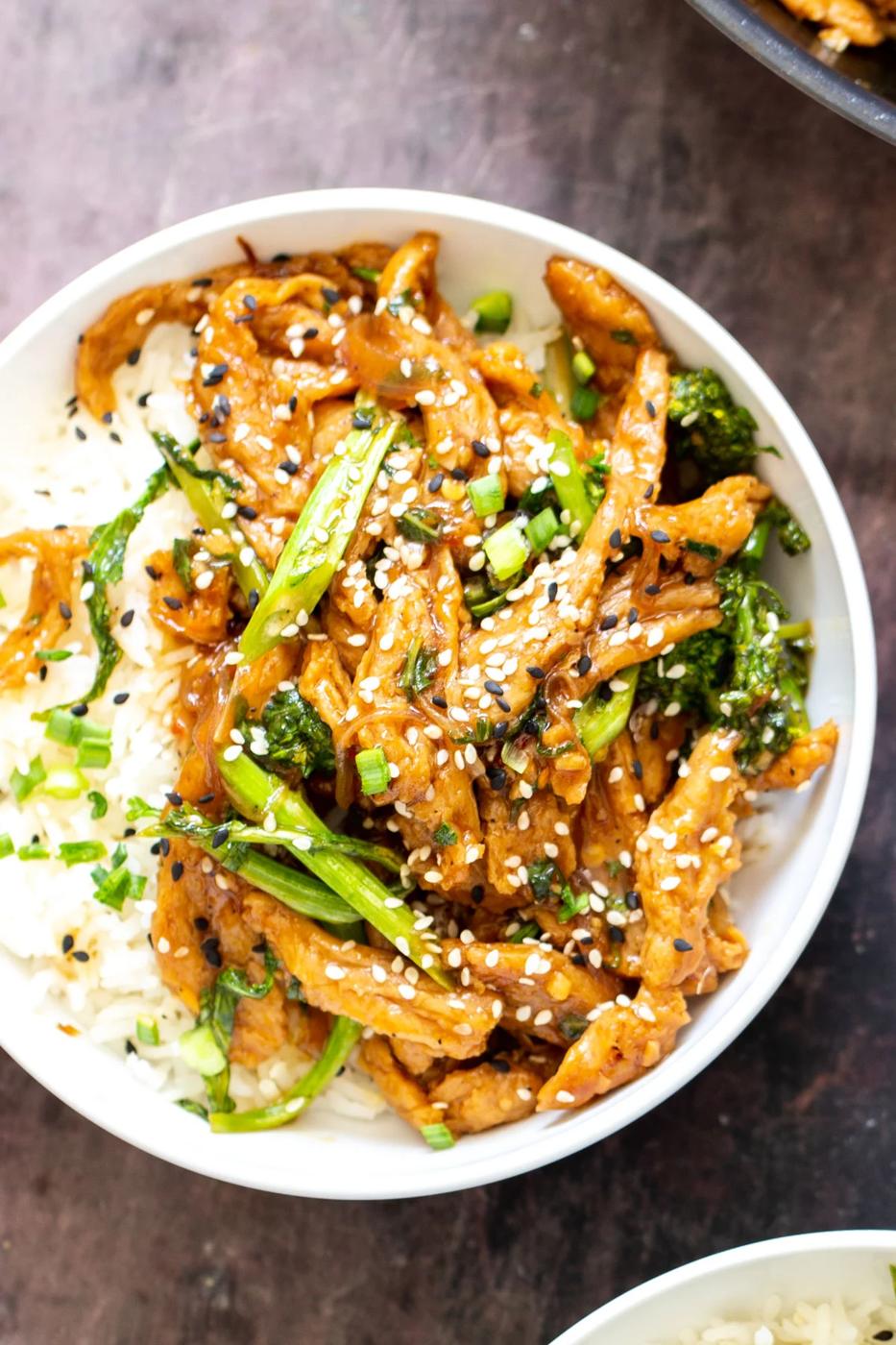 a bowl with rice and soy curl stir-fry sprinkled with sesame seeds