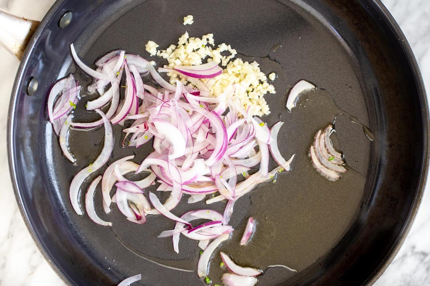 garlic and onion sauteeing in a frying pan
