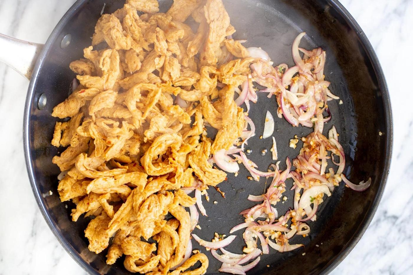 soy chunks in a frying pan with garlic and onions