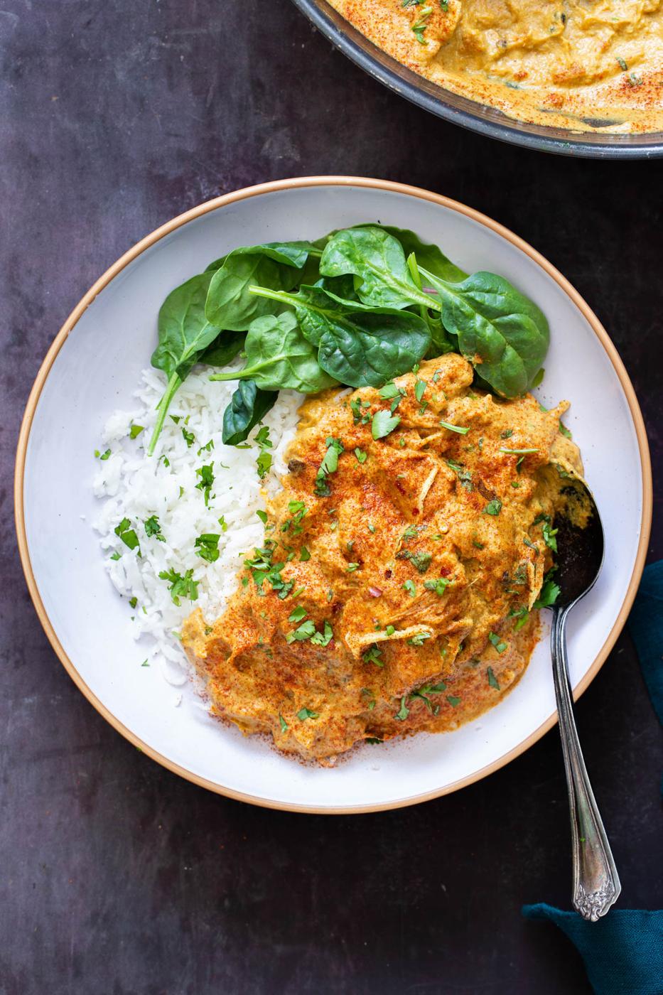 a serving of vegan shahi chicken korma with jackfruit served with rice and spinach