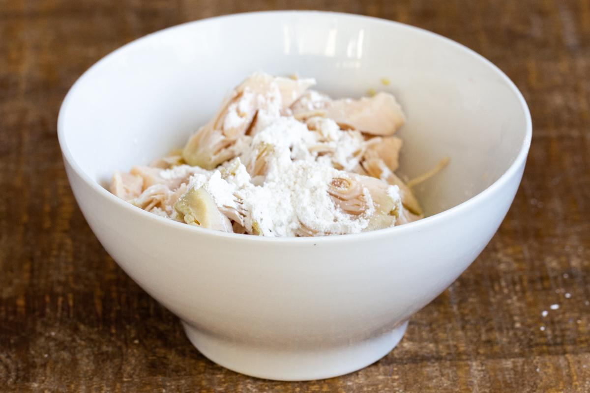 jackfruit chunks in a small white bowl coated with cornstarch