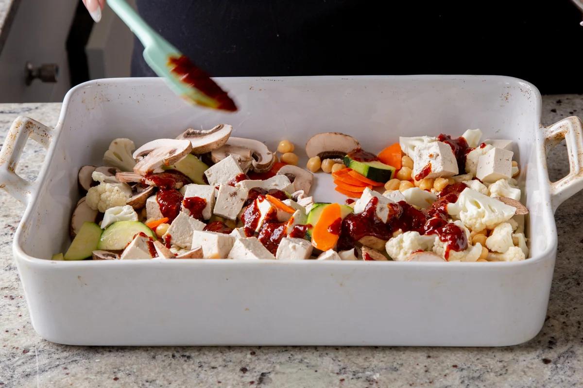 adding the gochujang marinade to the tofu and veggies in the pan