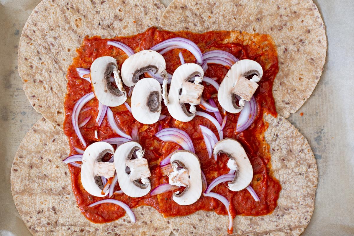 adding the mushrooms to the tortillas