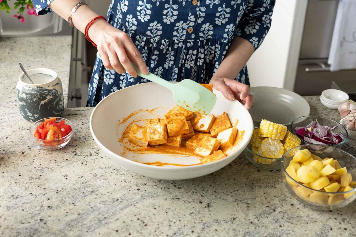 tossing the tofu in some of the peri-peri marinade