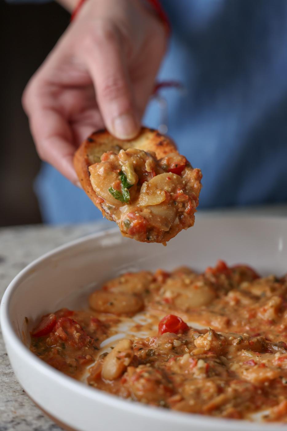 a piece of bread dipped into Sicilian pesto sauce butter beans