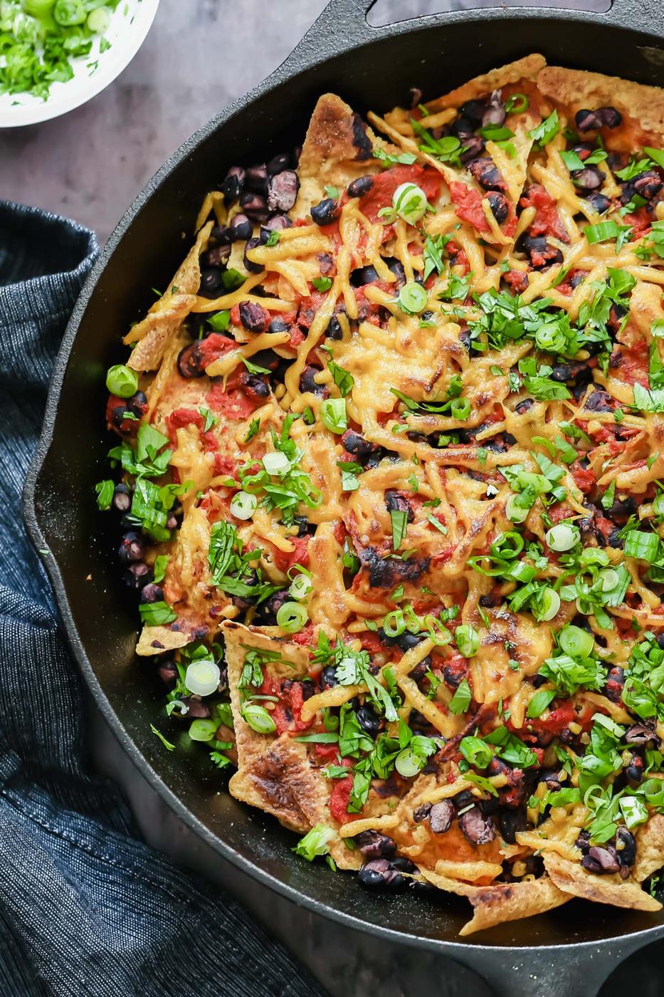 close-up overhead shot of vegan skillet enchiladas with tortilla chips, black beans and soy curls