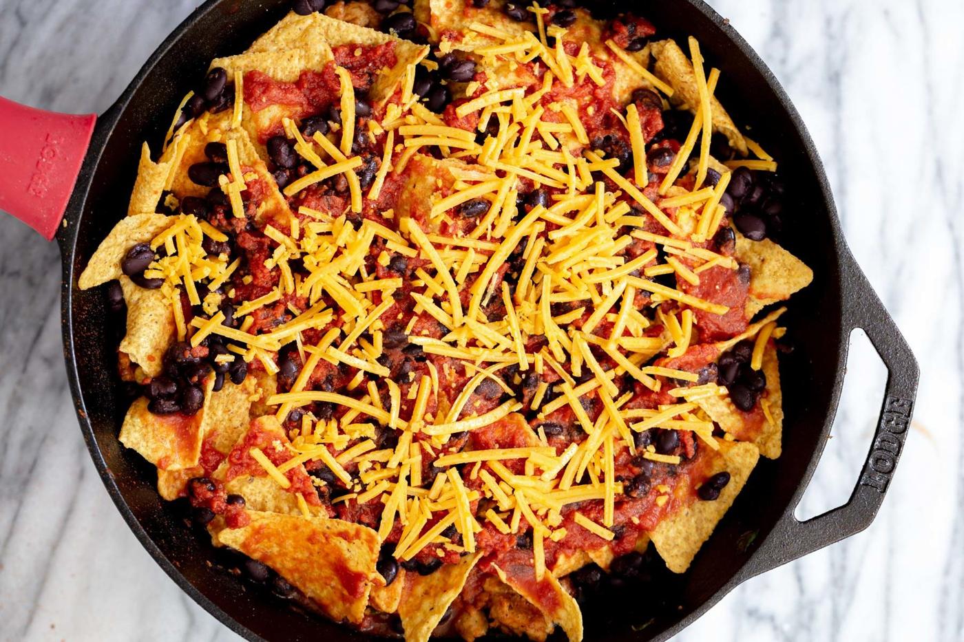 vegan skillet enchiladas being topped with vegan cheese shreds