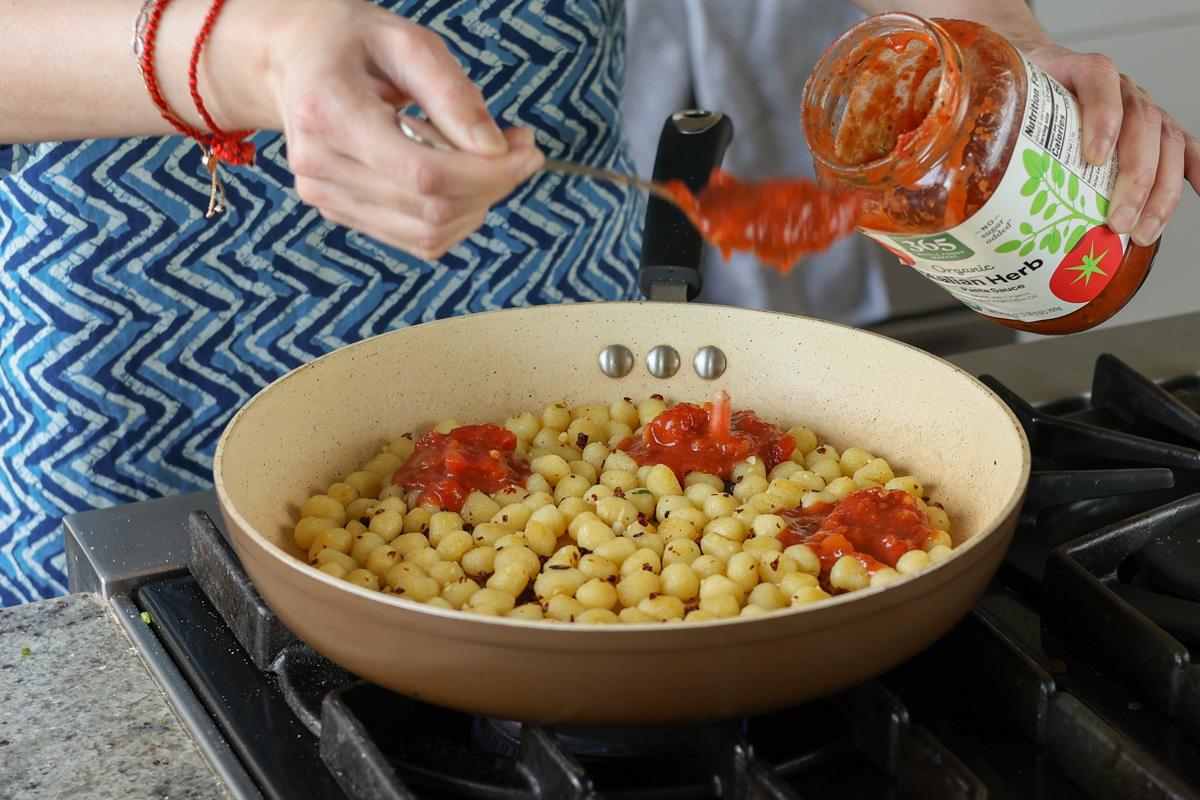 adding tomato sauce to the pan