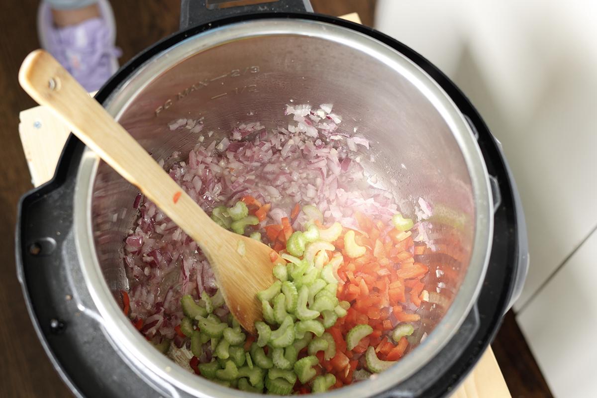 adding celery and bell pepper to cooked onions