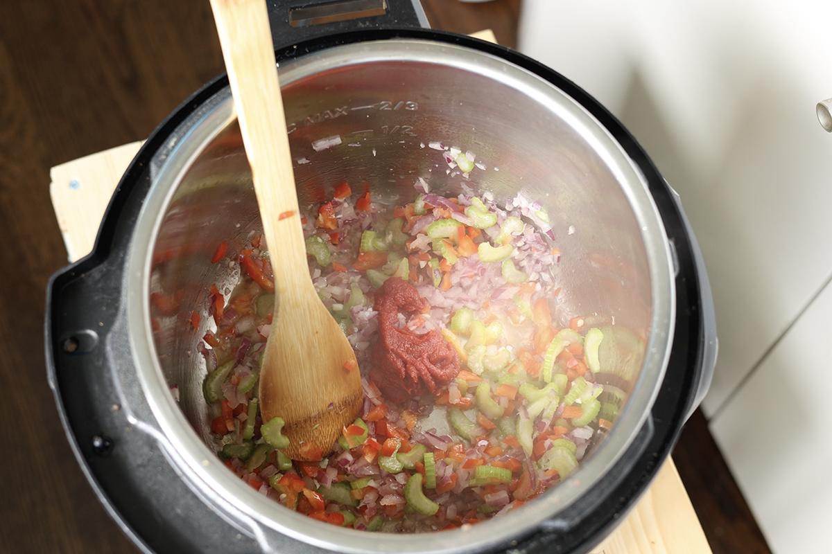 adding tomato paste to the pot