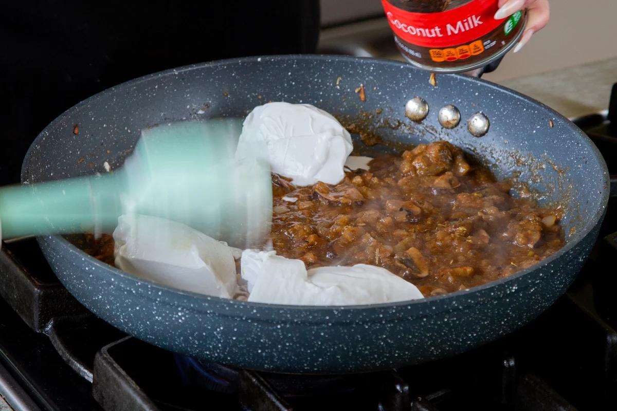 adding coconut milk to the mushroom-onion mixture