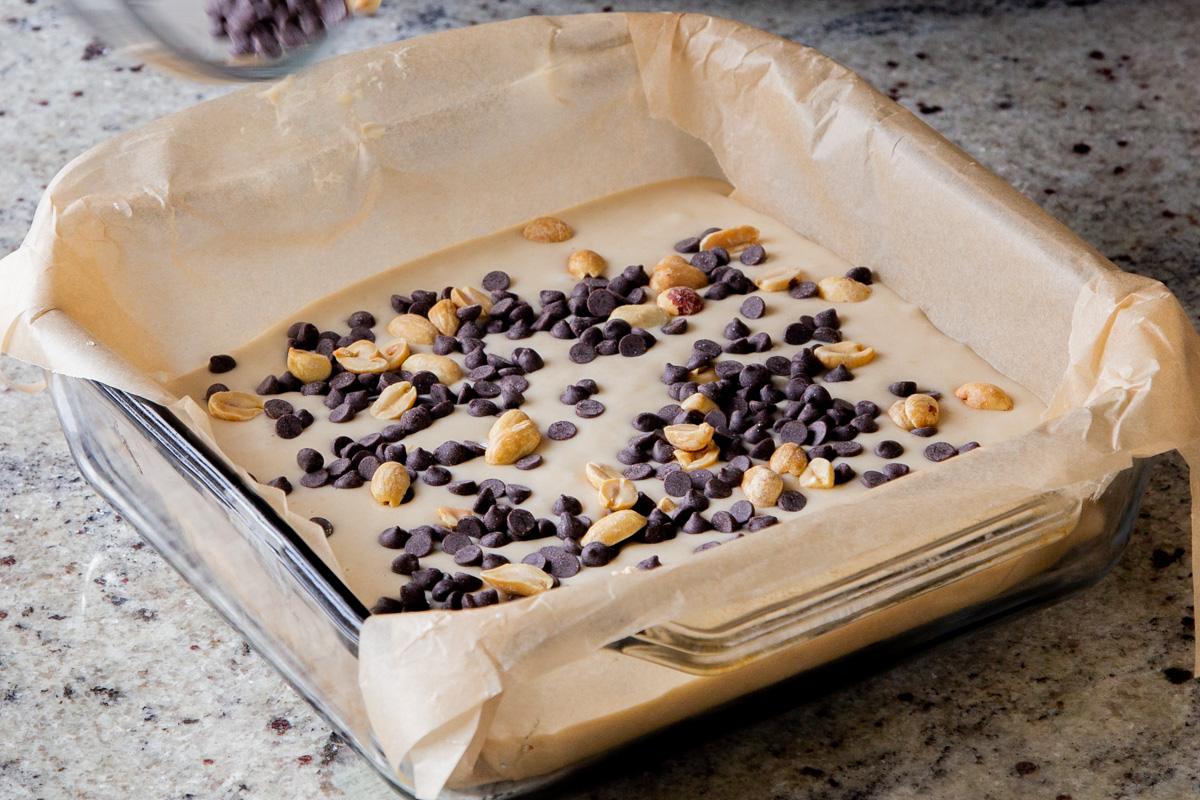 adding peanuts and chocolate chips to the cake batter