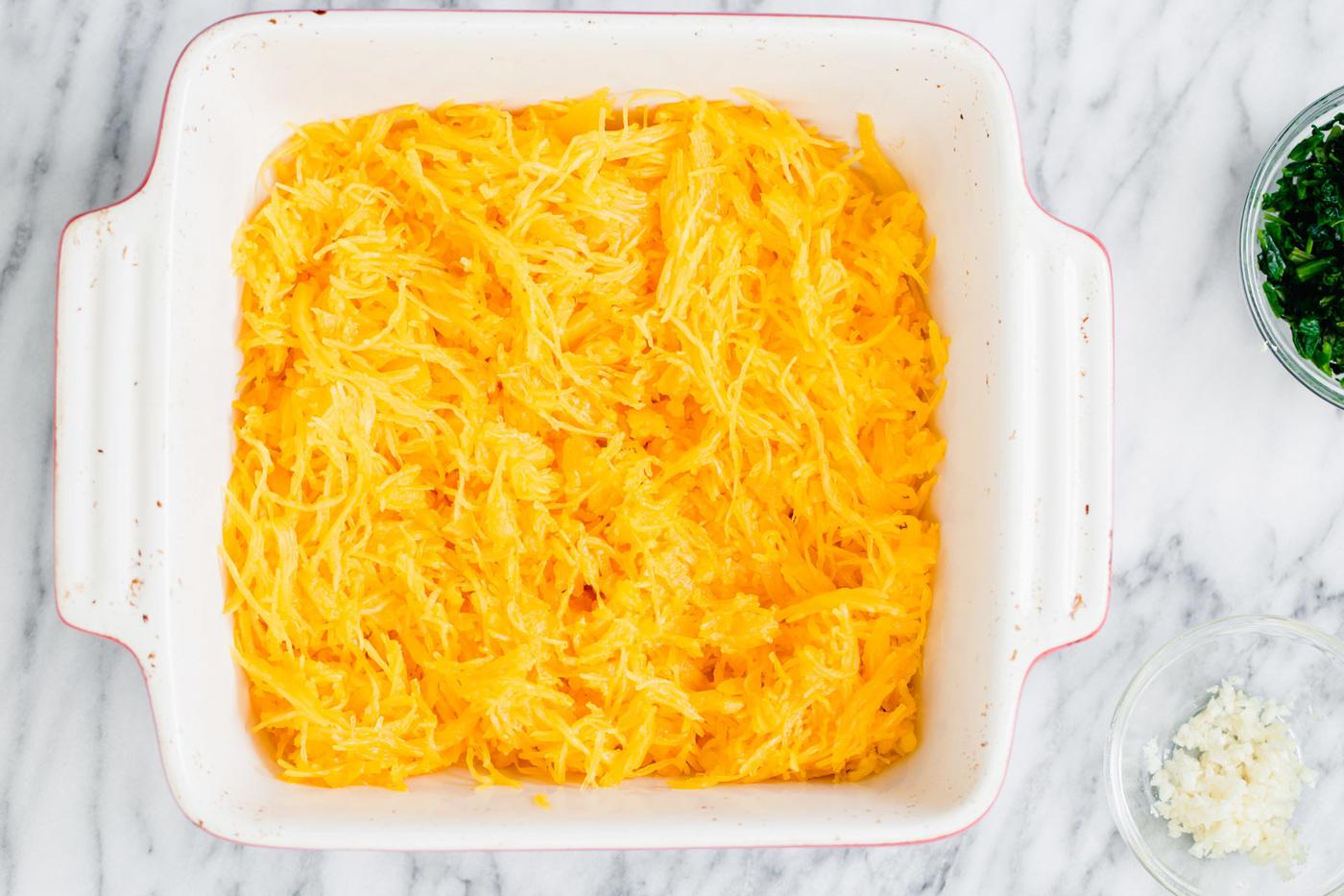 cooked spaghetti squash noodles in a white casserole dish