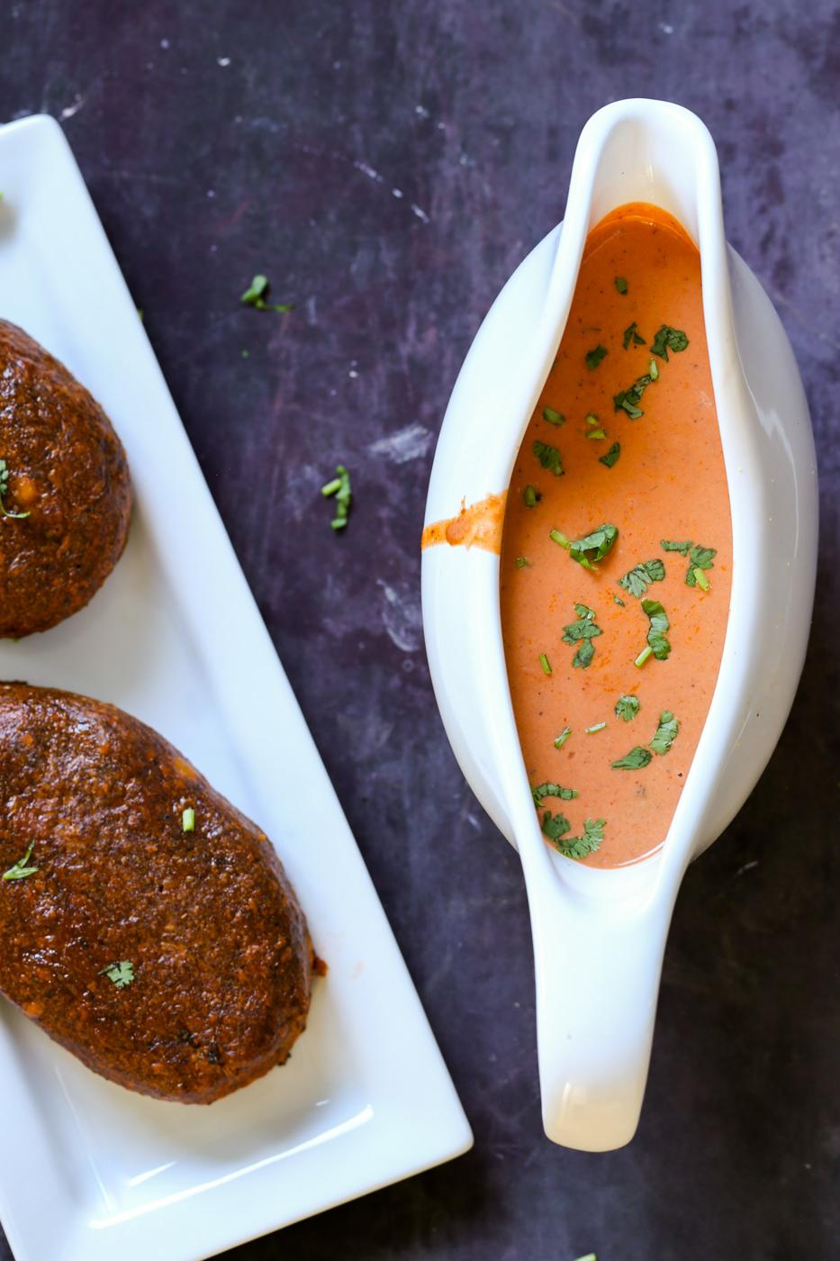 gravy boat of butter chicken sauce next to the chickpea loaves