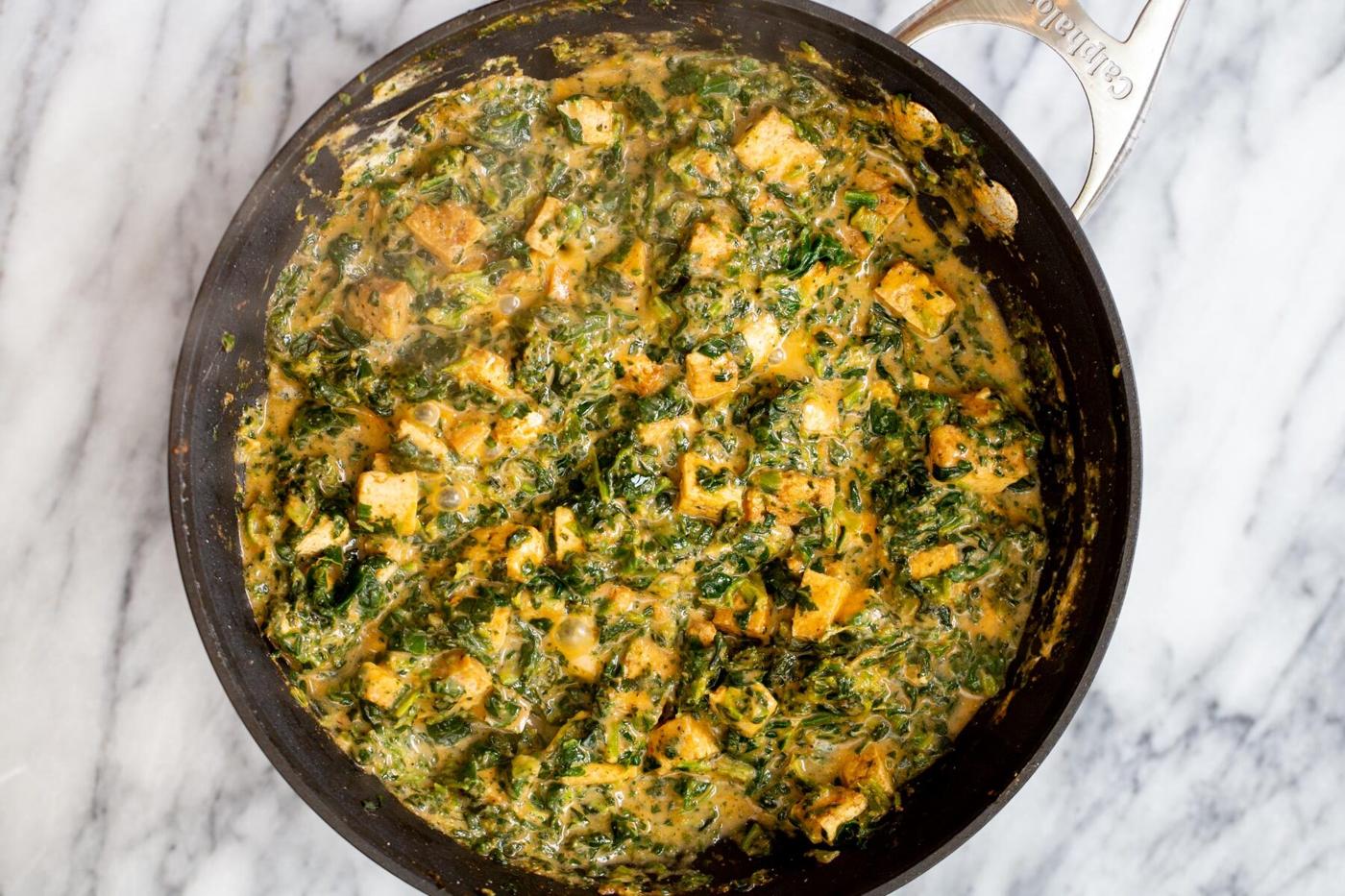 tofu in a skillet in creamy spinach gravy