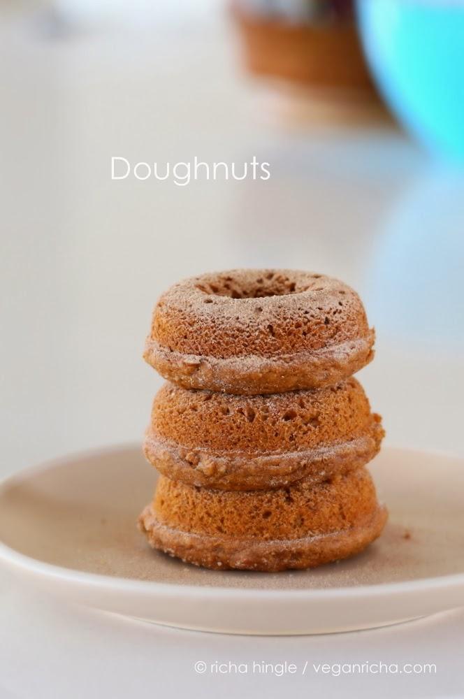 three cinnamon sugar-dusted vegan baked sweet potato donuts on a white plate