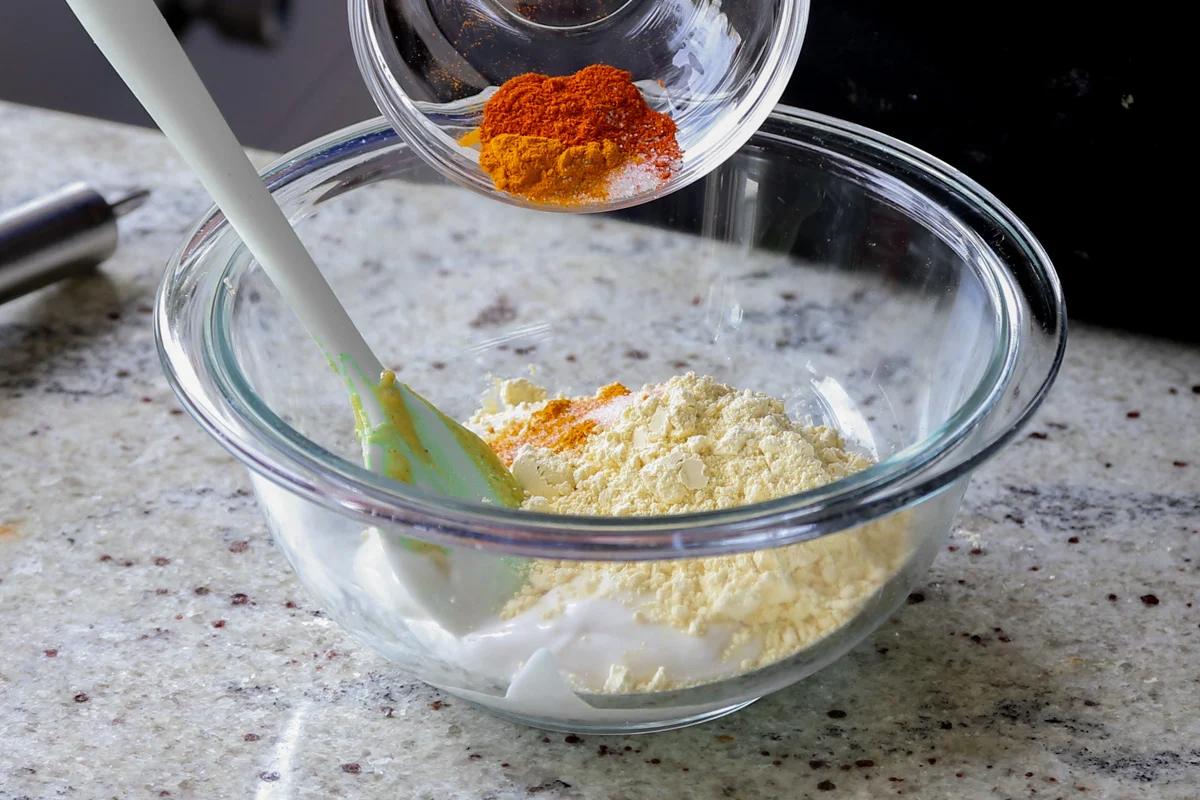 adding chickpea flour and spices to the yogurt