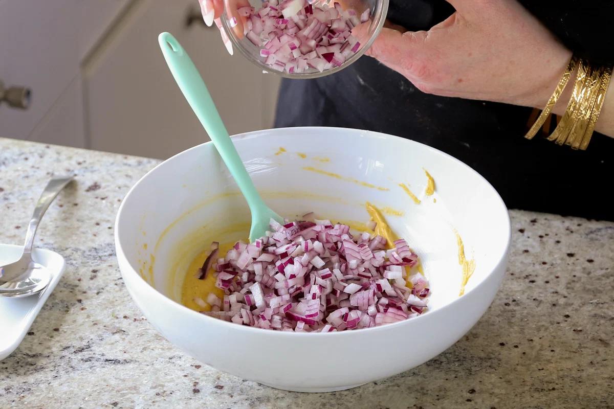 adding onion to the pakora batter