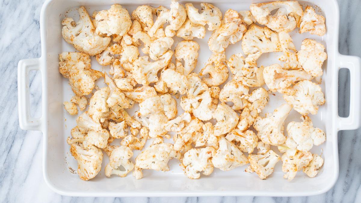 cauliflower florets sprinkled with bbq spices ready for roasting