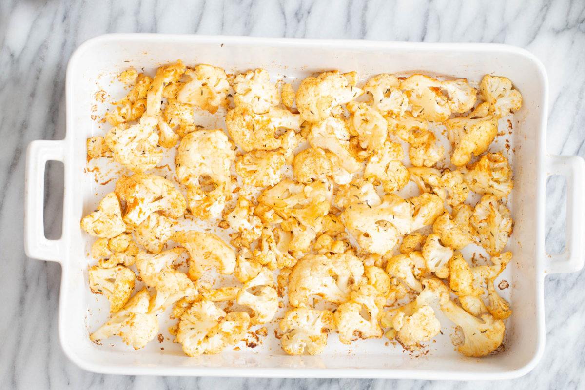 overhead shot of a white casserole with oven roasted bbq spiced cauliflower florets
