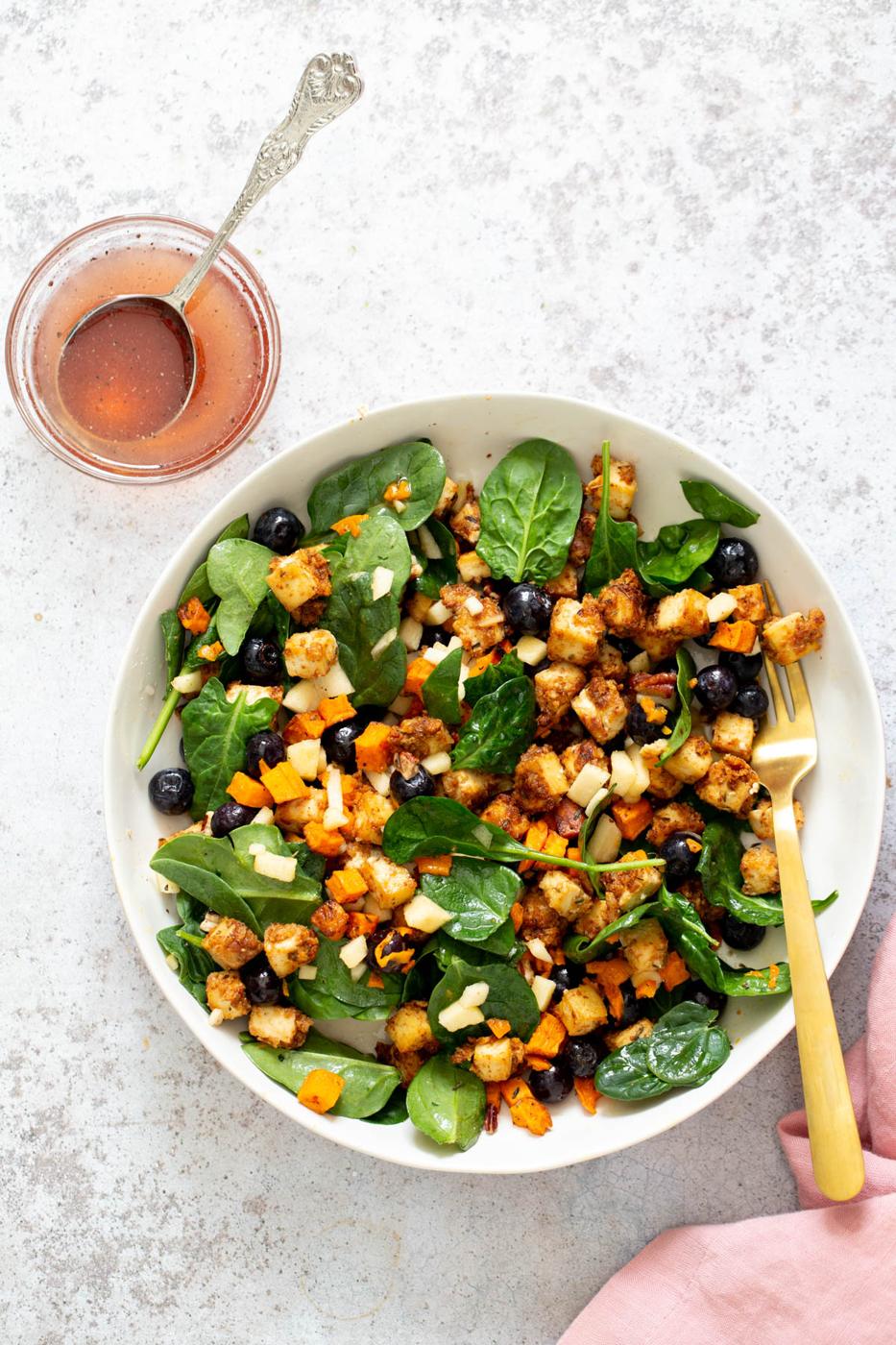 sweet potato tofu bowls with blueberries and chunks of apple tossed in a shallow white bowl with maple mustard dressing