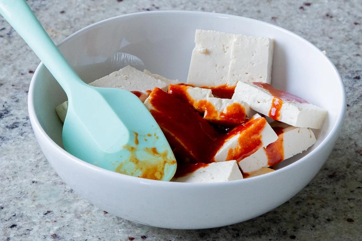 sliced tofu in a bowl with gochujang added