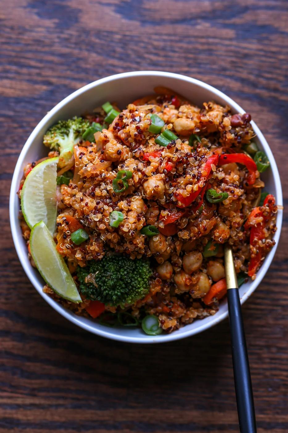 quinoa chickpea casserole in a bowl with lime wedge and green onion