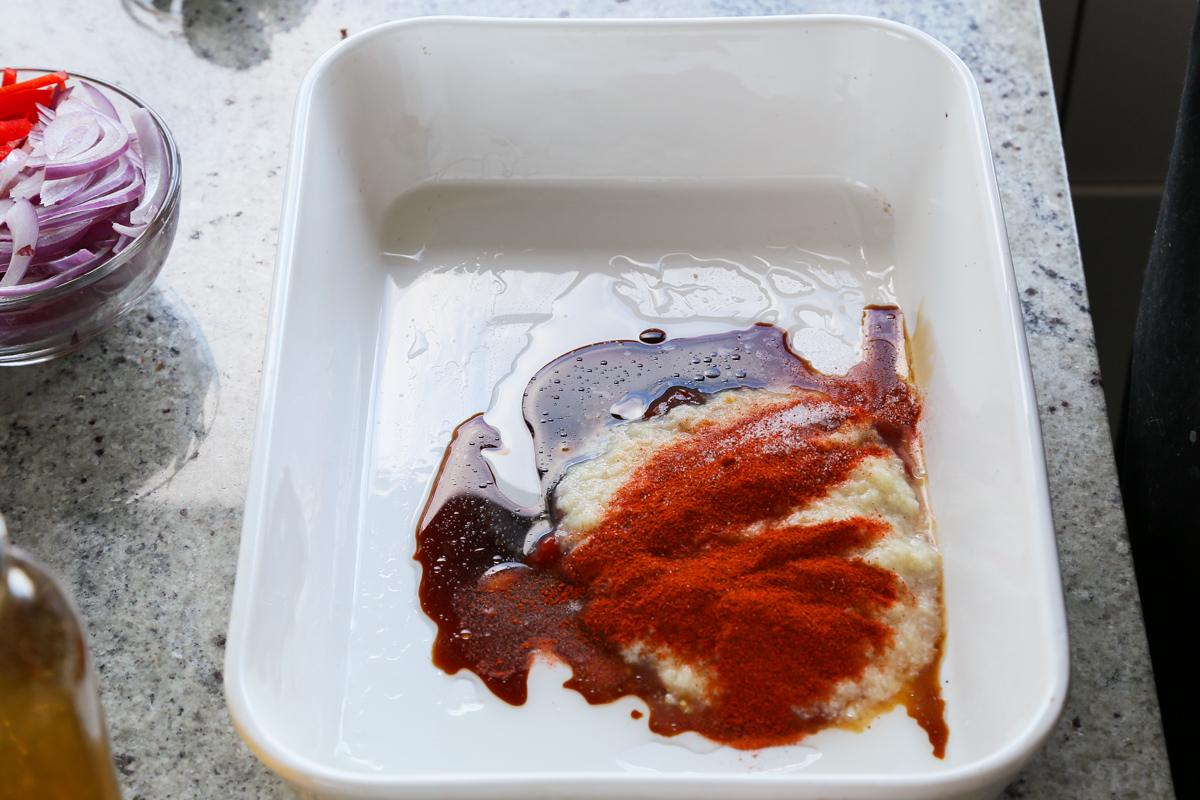 mixing ginger garlic paste, sauces, and spices in the pan