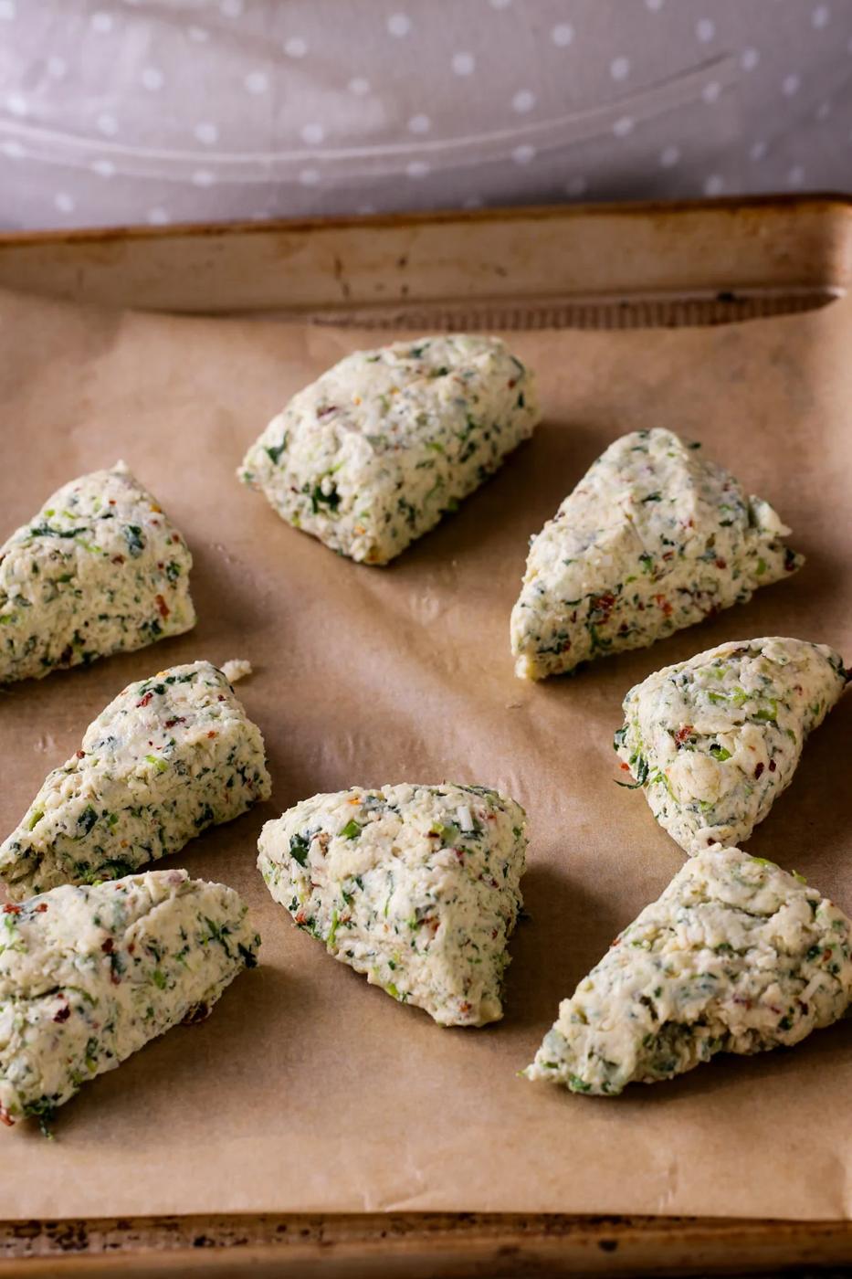 vegan spinach and cheese scones arranged on the baking sheet before baking