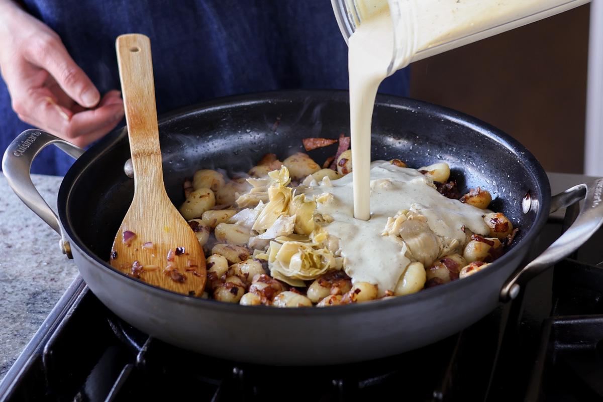 adding cream sauce to the pan