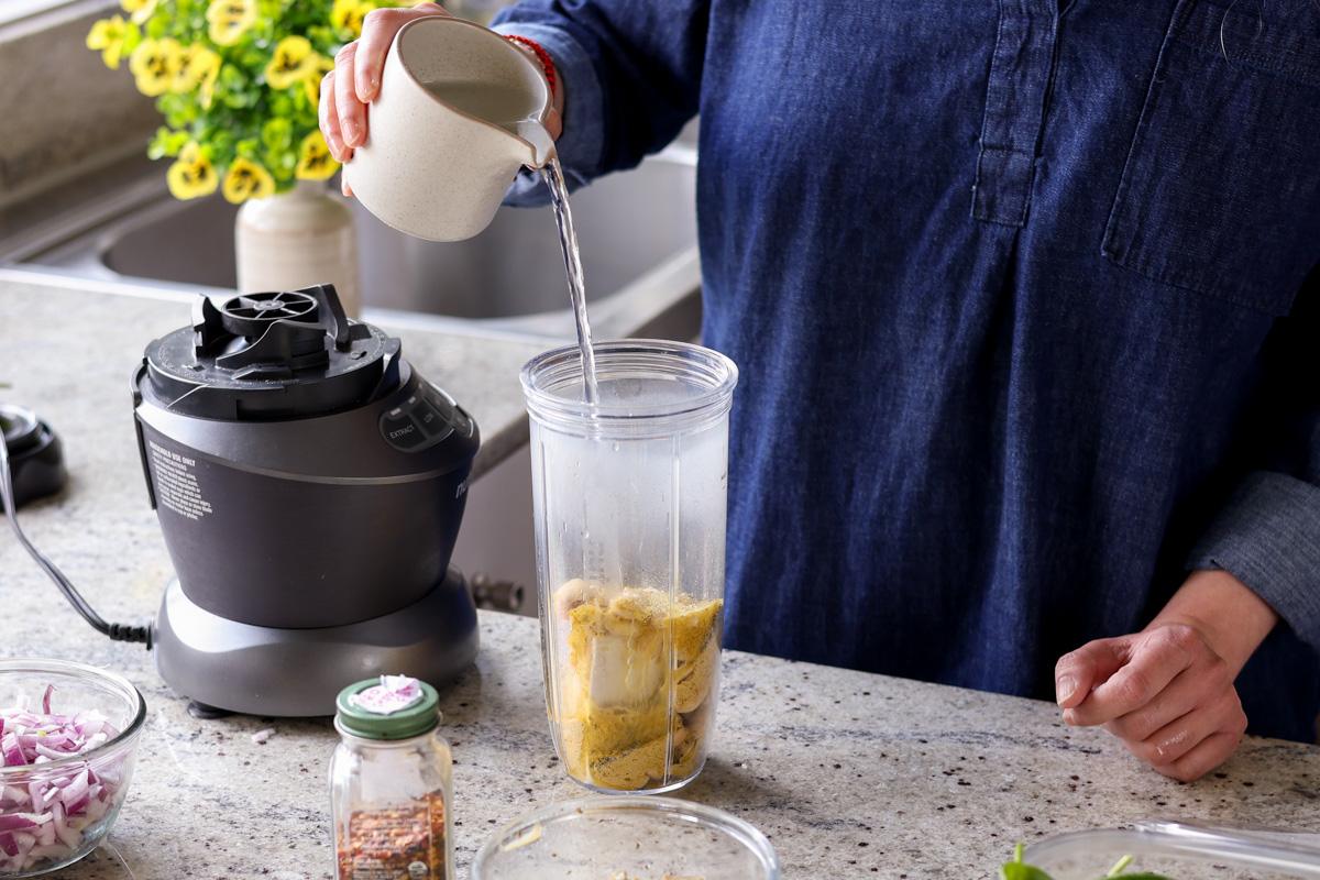 pouring cream sauce ingredients into the blender