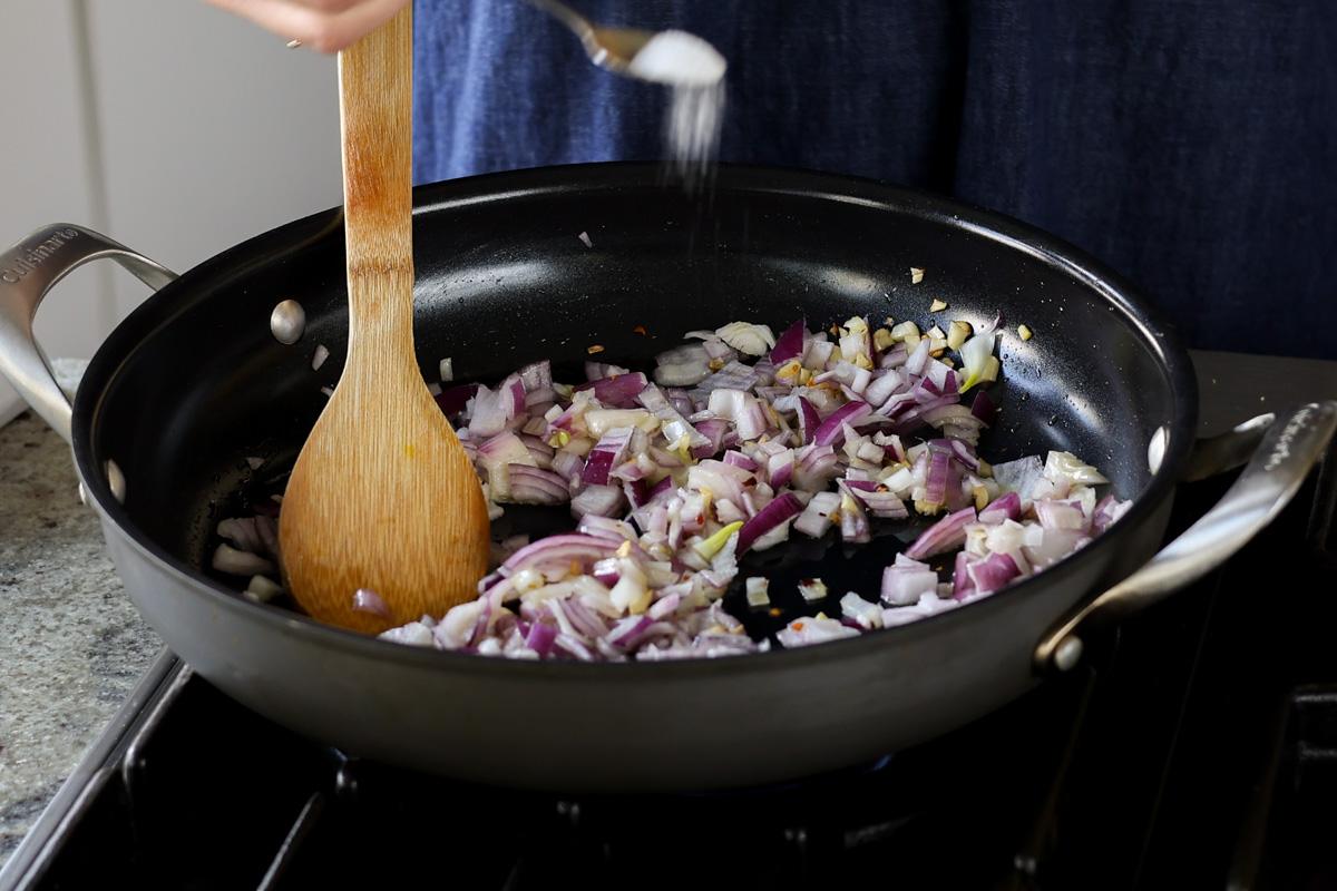 adding chopped onion to the pan