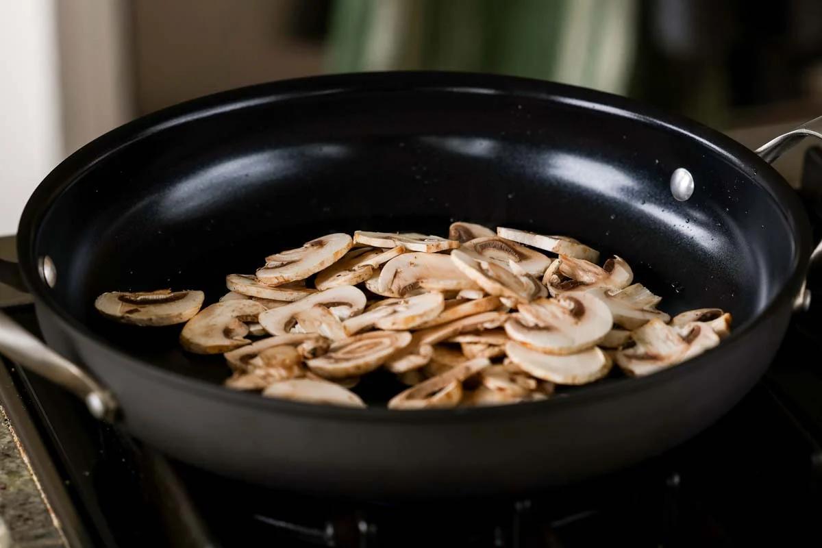 adding mushrooms to the pan