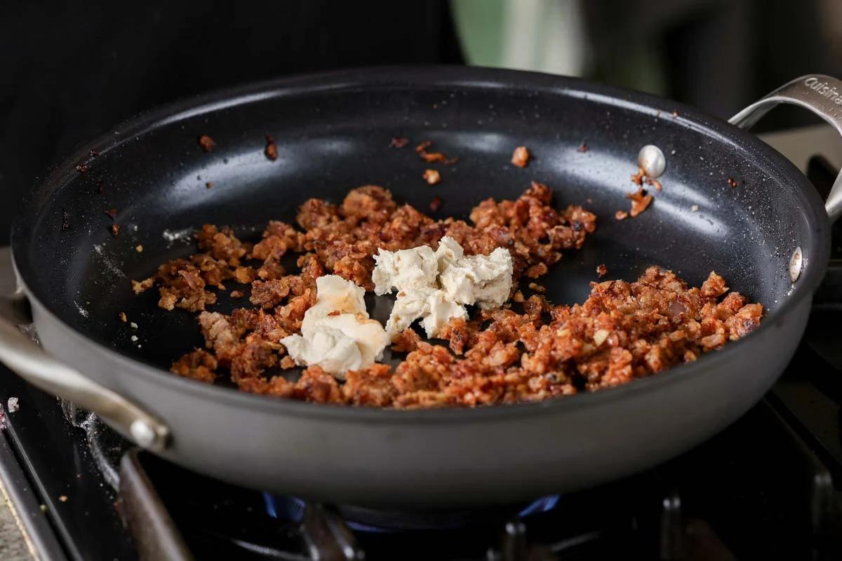 adding vegan cream cheese to the pan