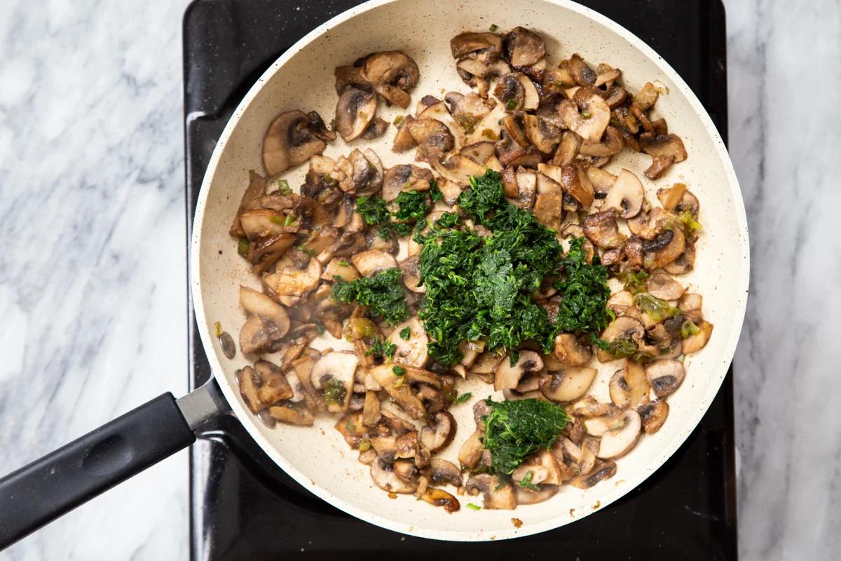 mushroom and spinach in a sauteeing pan