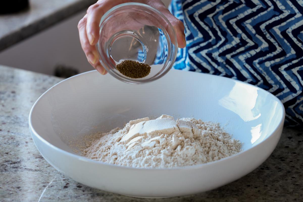 adding carom seeds to the flour mixture