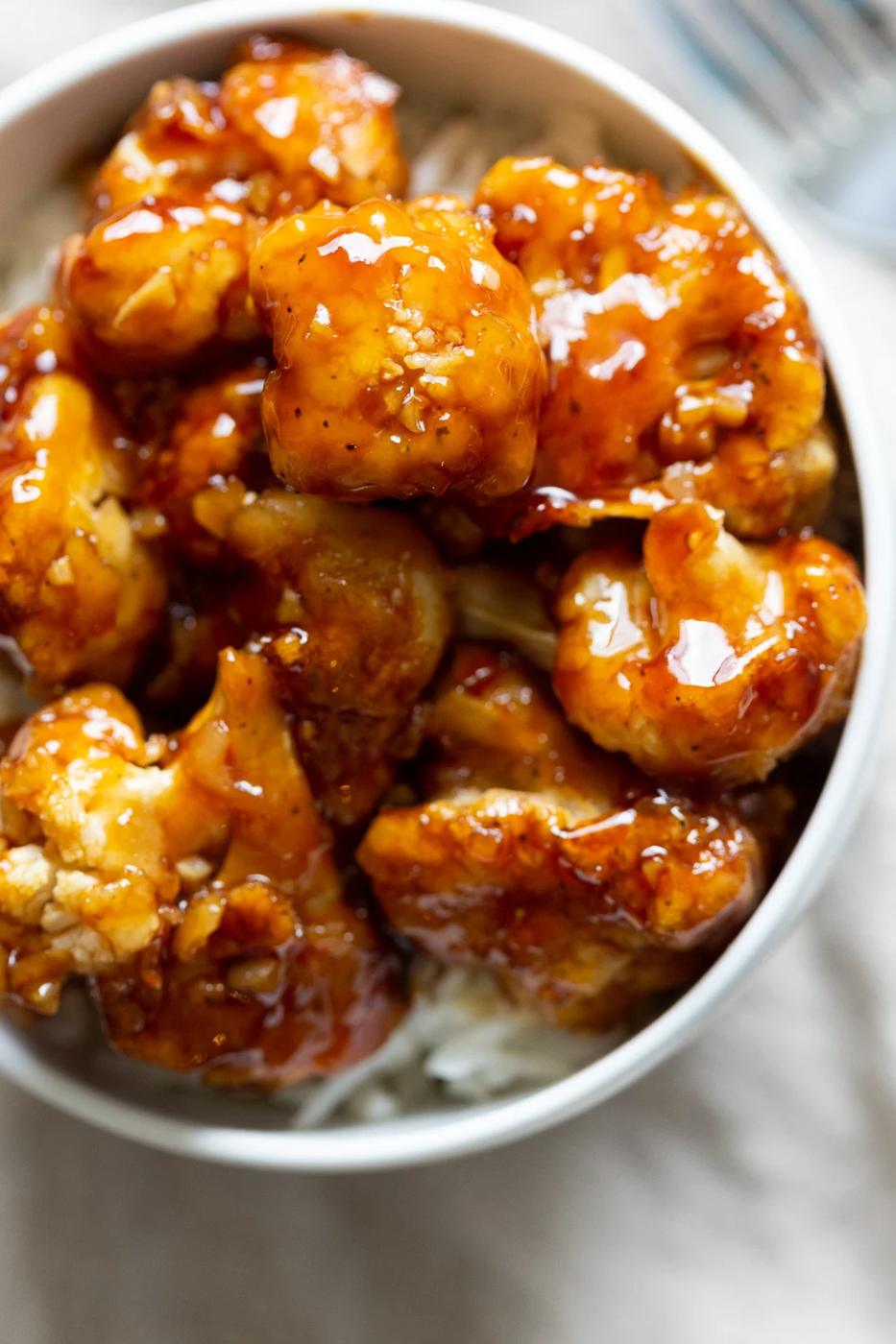 Vegan Sticky Sesame Cauliflower over rice in a white bowl
