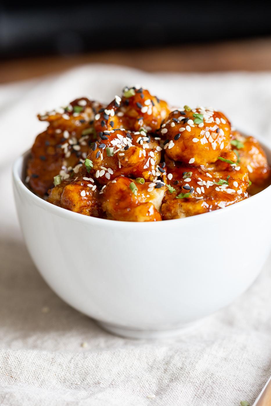 Vegan Sticky Sesame Cauliflower over rice in a white bowl