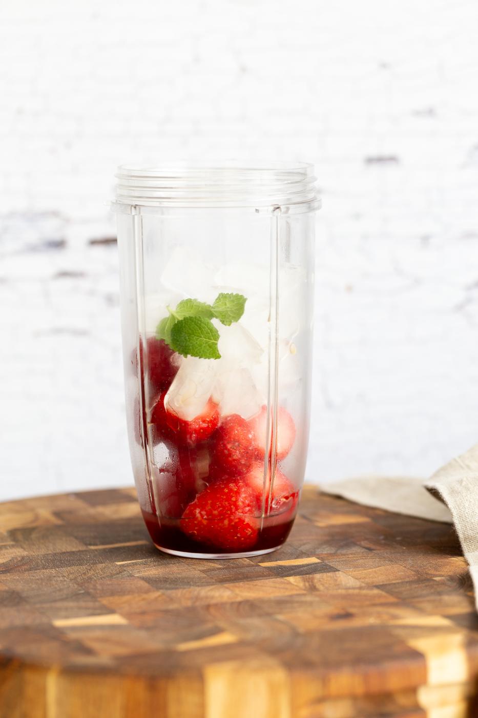 ice cubes fresh mint and frozen strawberries in a blender