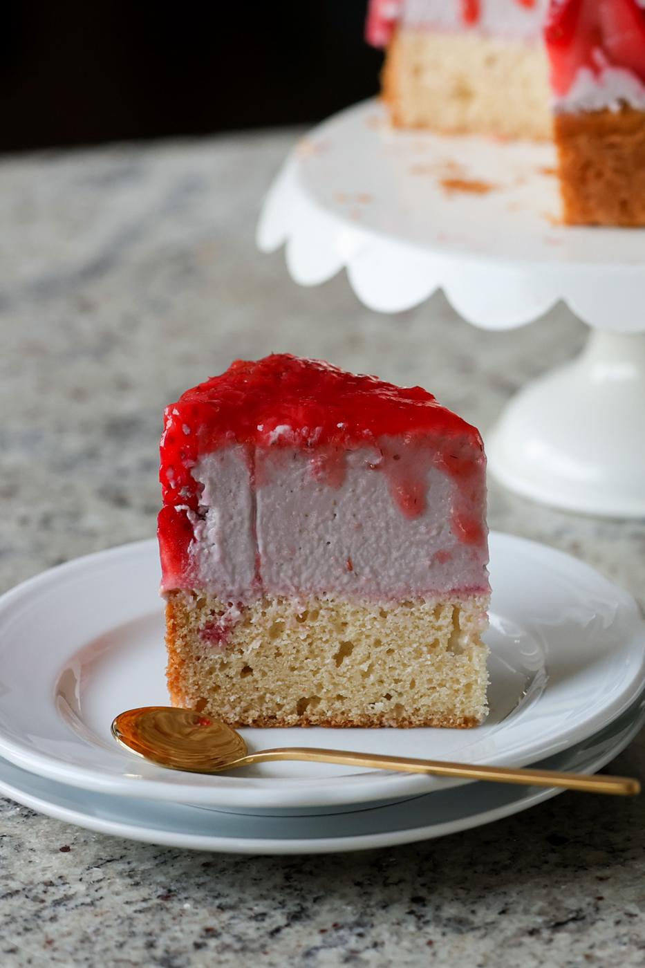 slice of strawberry mousse cake on a plate with a spoon