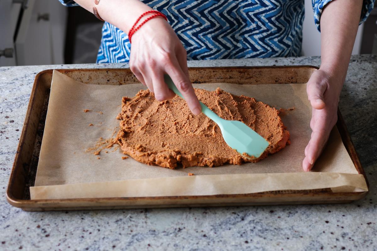 spreading the sun dried tomato roast mixture onto the baking sheet