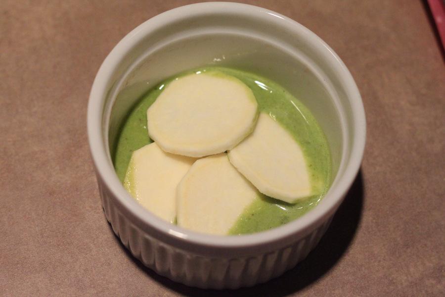 spinach alfredo sauce and white sweet potatoes in a small white casserole dish