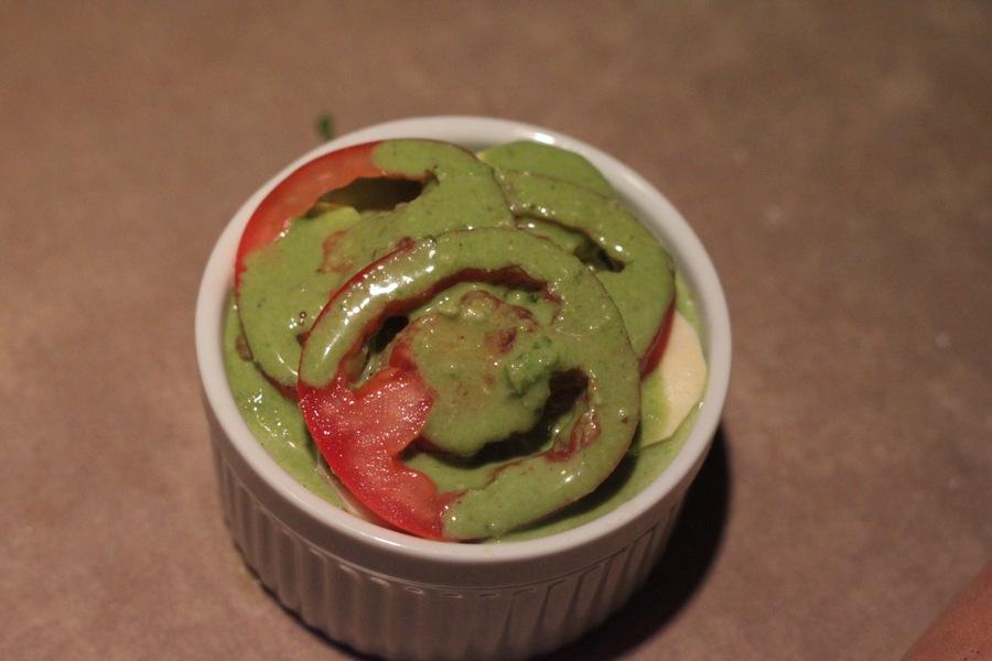 tomatoes, white sweet potatoes and spinach alfredo sauce in a small white casserole dish