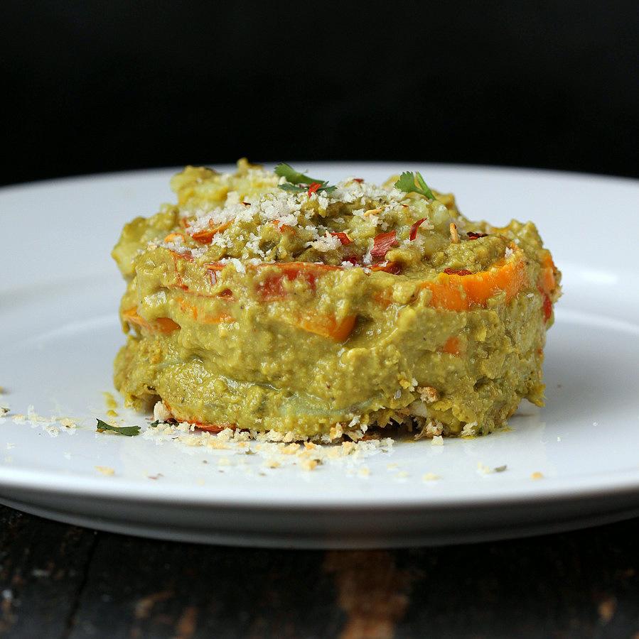 side view of vegan sweet potato spinach alfredo bake on a white plate