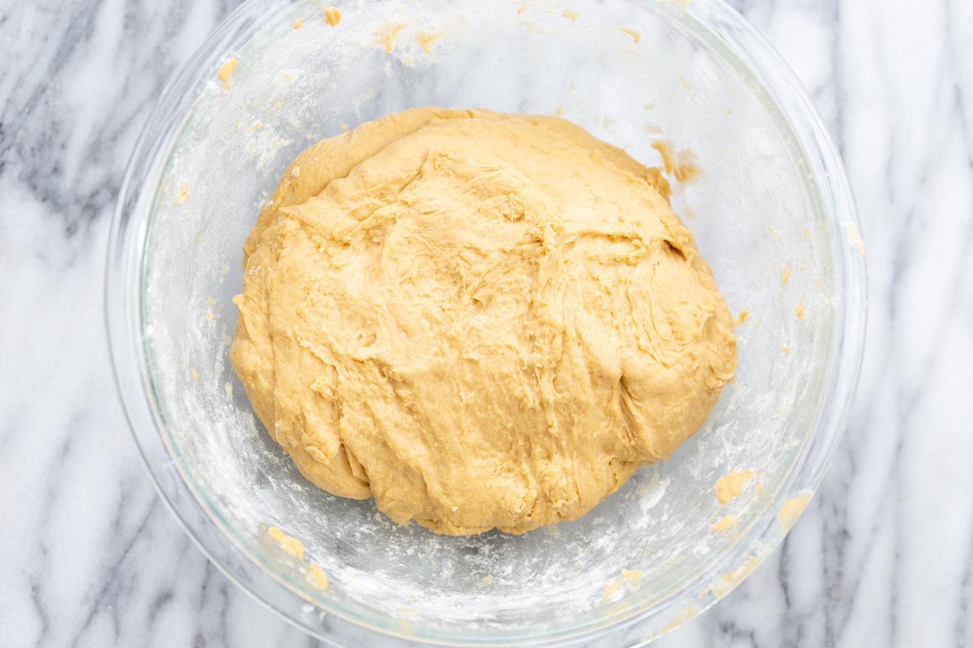 overhead shot no yeast cinnamon roll dough in glass bowl