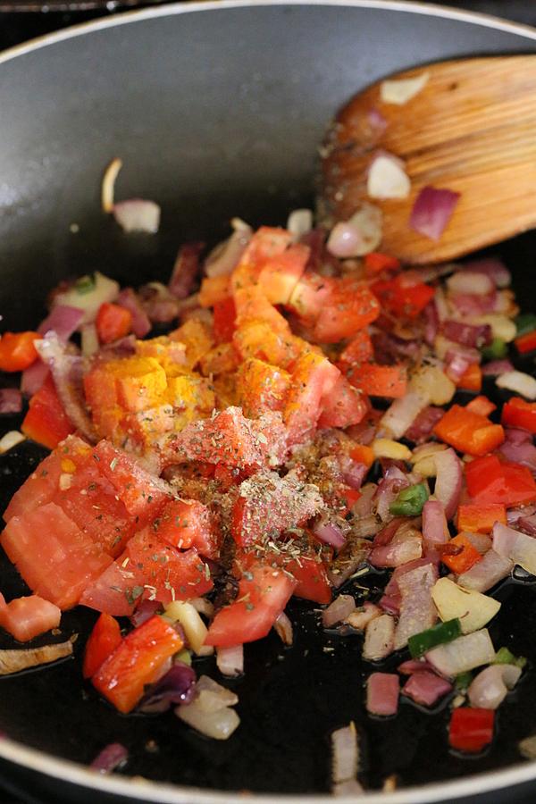 bell peppers, garlic, onion and tomatoes sauteeing in a pan