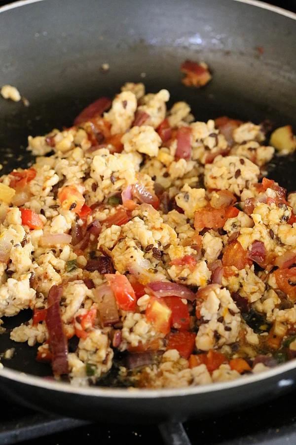 vegan tempeh scramble sauteeing in a pan with veggies